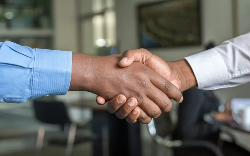 Two business leaders shaking hands in an office